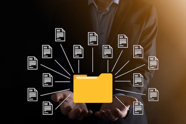 Système de gestion de documents DMS .Homme d'affaires détiennent le dossier et l'icône du document.Logiciel d'archivage, de recherche et de gestion des fichiers et des informations d'entreprise.Concept de technologie Internet.Sécurité numérique