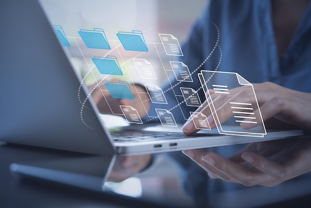 Système de gestion de documents DMS mis en place par un consultant informatique travaillant sur un ordinateur portable au bureau Logiciel pour l'archivage des fichiers d'entreprise