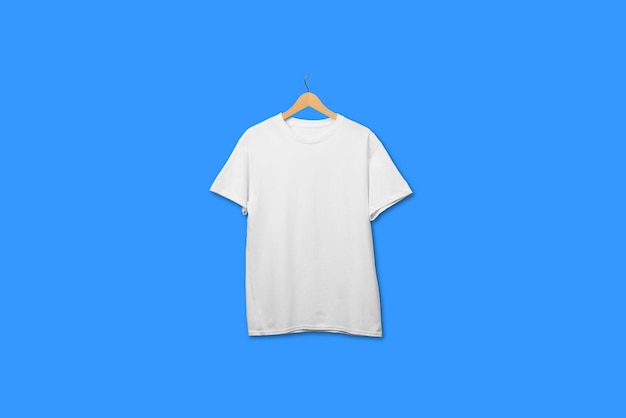 T-shirt blanc sur cintre en bois flottant sur fond uni