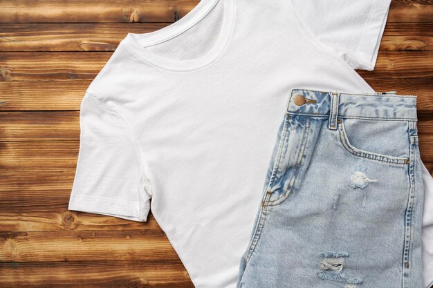 T-shirt blanc et jeans sur fond de bois brun