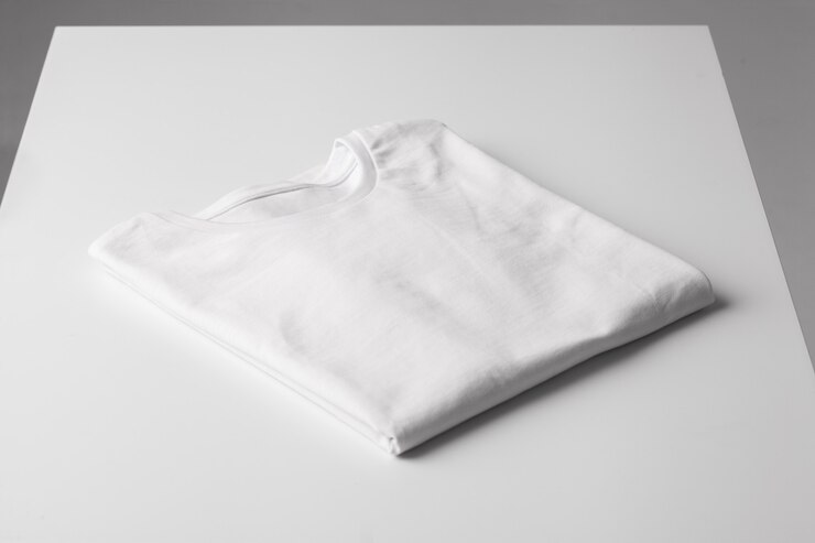 t-shirt blanc plié de base sur une table grise maquette pour t-shirt de marque