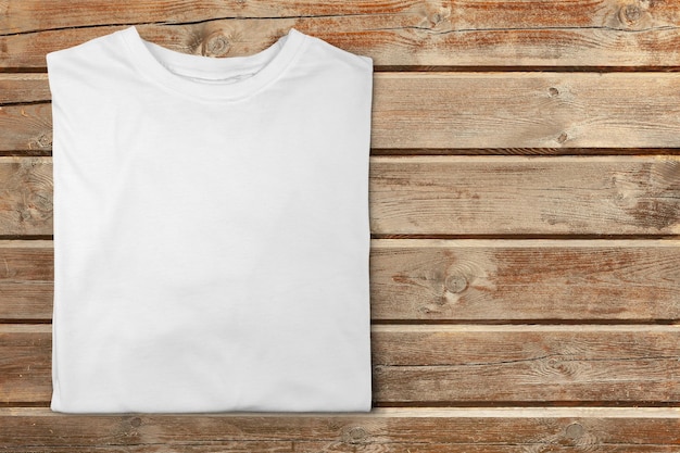 Photo t-shirt blanc sur la vue de dessus de table en bois