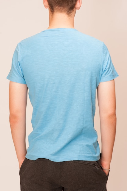 T-shirt bleu sur un jeune homme isolé, dos