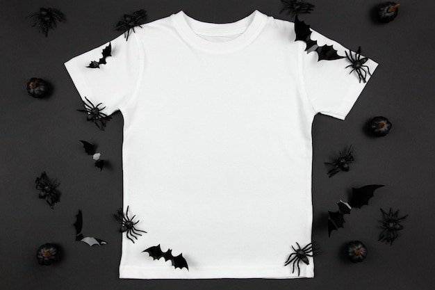 Photo t-shirt en coton blanc pour femmes maquette d'halloween avec des citrouilles, des araignées et des chauves-souris sur fond noir modèle de t-shirt de conception présentation d'impression maquette vue de dessus à plat