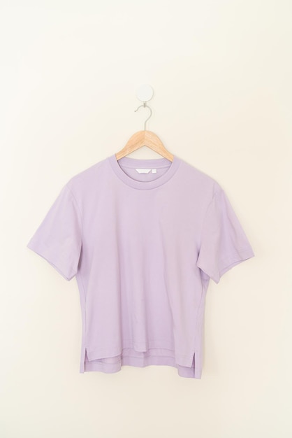 t-shirt femme suspendu avec cintre en bois sur le mur