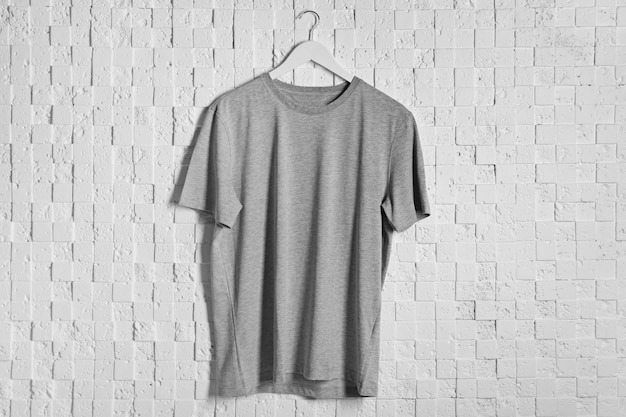 Photo t-shirt gris blanc sur un fond texturé clair