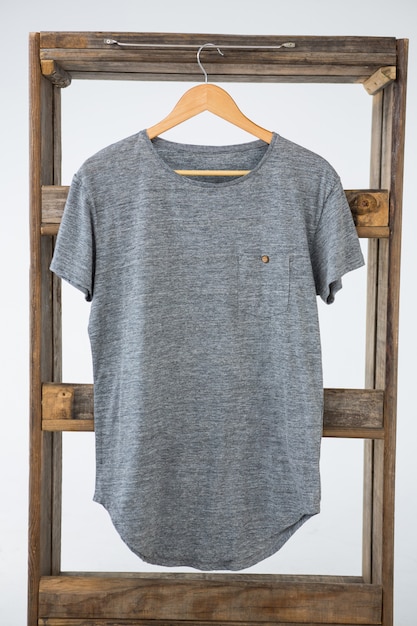 T-shirt gris suspendu à un cadre en bois