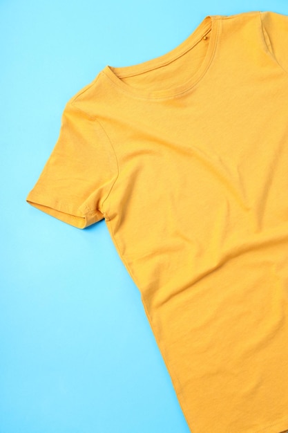 Photo t-shirt jaune vierge avec espace pour imprimer sur fond bleu