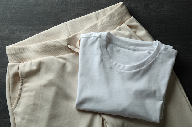 T-shirt et pantalons de survêtement blanc sur bois foncé