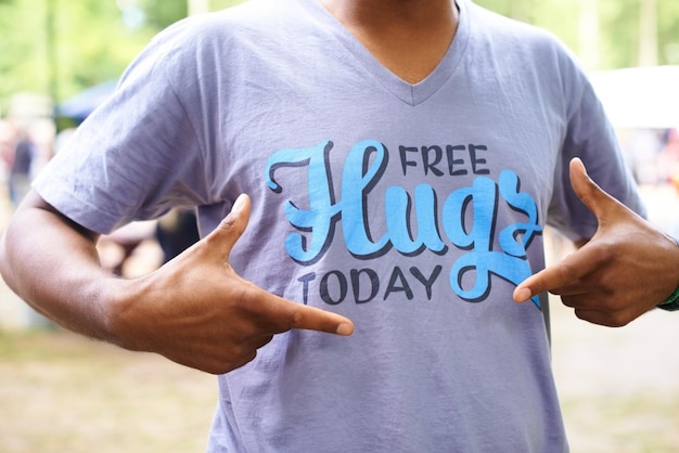 T-shirt en plein air et homme avec du plaisir pointant et des câlins gratuits aujourd'hui avec fête et promotion slogan motivationnel personne et gars avec une tenue décontractée et des vêtements élégants avec le soleil et les vacances d'été