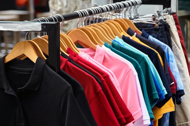 T-shirt de polo coloré pour l'homme sur des couvertures en bois dans un magasin de détail