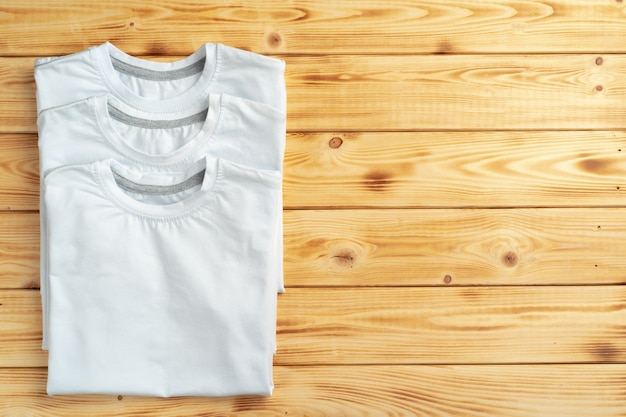 T-shirts blancs sur une surface en bois