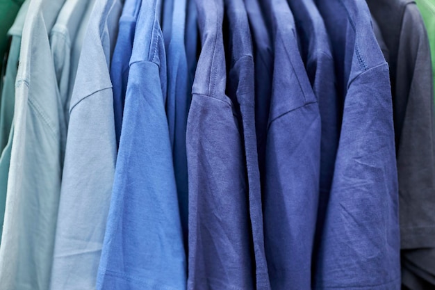 t-shirts bleus pour hommes sur des cintres dans un magasin de vêtements. T-shirts bleus pour hommes suspendus à des cintres dans le st