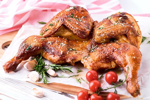 Tabac de poulet grillé sur papier sur fond de bois blanc