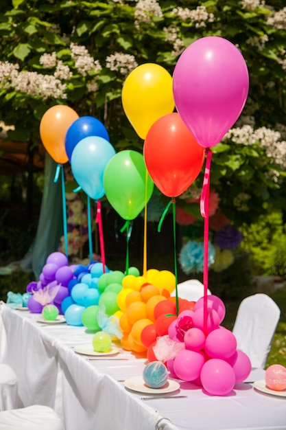 Table d'anniversaire avec des ballons arc-en-ciel. Vacances d'été dans le parc.