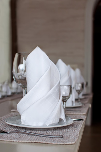 Table de banquet blanche servie pour une fête ou une célébration de mariage assiettes et serviettes propres