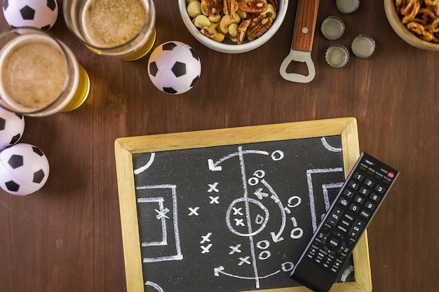 Table avec de la bière et des collations salées pour la fête du football.