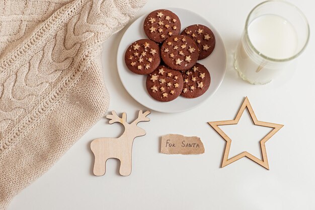 Sur une table blanche une soucoupe avec des biscuits aux pépites de chocolat rond