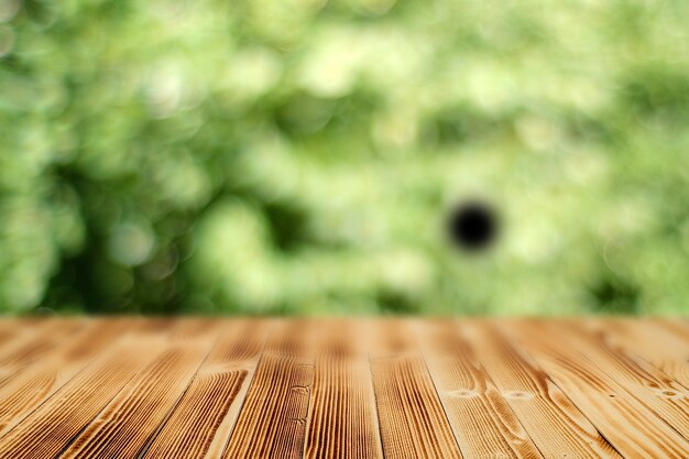 Photo table en bois avec un arrière-plan flou d'une forêt verte d'été avec bokeh.