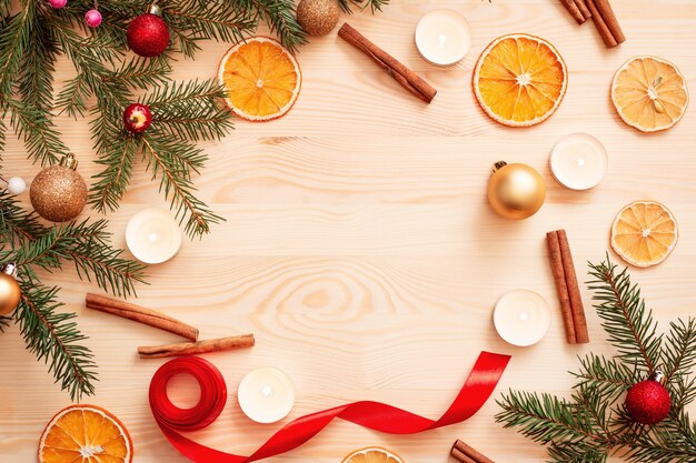 Table en bois avec branche d'arbre de Noël et différentes décorations avec un espace vide au milieu