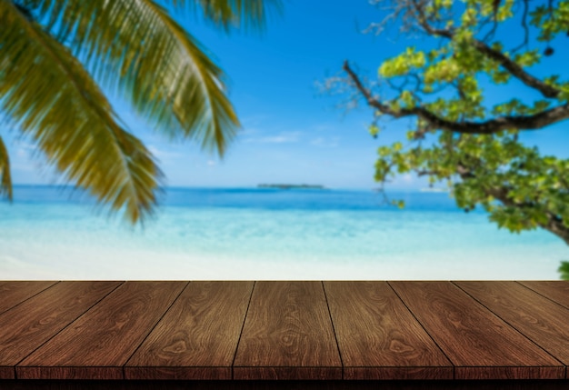 Table en bois brun sur la plage tropicale d'été avec copie espace vide sur la table pour la maquette d'affichage du produit