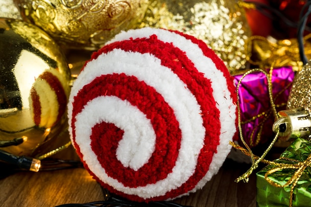 Table en bois avec décorations de Noël. Boules rouges, argentées et dorées, coffrets cadeaux, lumières, panettone, sapin de Noël et autres. Mise au point sélective.