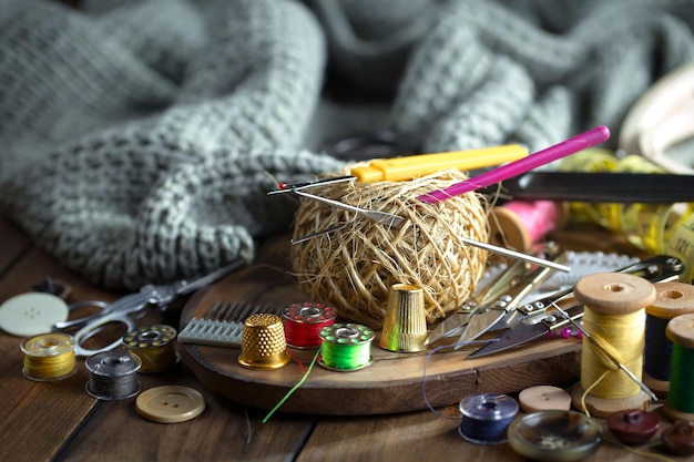 Photo une table en bois avec diverses fournitures de couture dont un crochet et un crochet jaune et rose.
