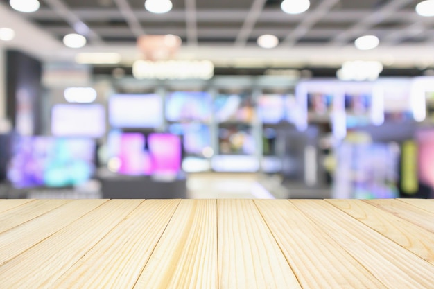 Table en bois avec émission de grand magasin électronique Télévision Télévision et appareil ménager arrière-plan flou