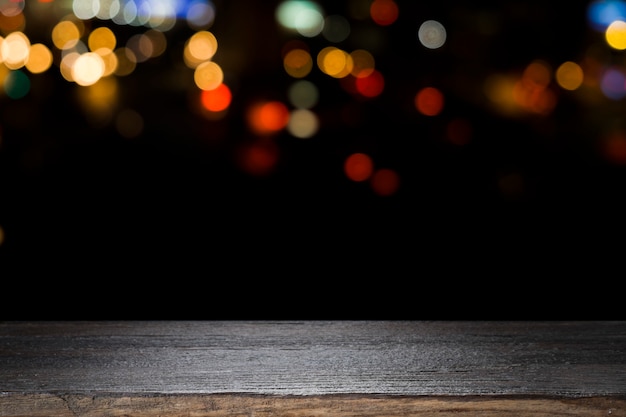 Table en bois sur flou bokeh de fond de lumière de nuit.