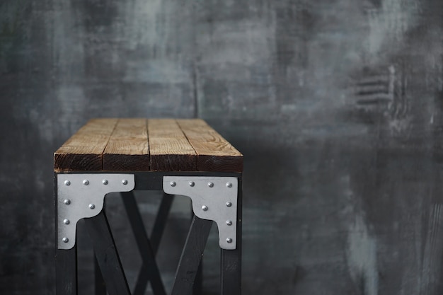 Table en bois avec inserts métalliques. Table de style loft sur le fond d'un mur sombre de style grunge et loft