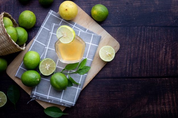 Table en bois avec jus de citron fraîchement pressé à la menthe et tranches de citron.