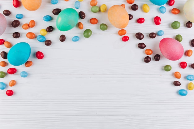 Table en bois à Pâques autour des oeufs et des bonbons.