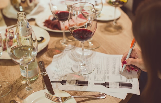 Sur une table en bois parmi des verres de vin et des assiettes