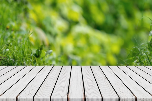 Table en bois de planche blanche vide avec fond de feuillage vert bokeh pour montage et affichage de produits