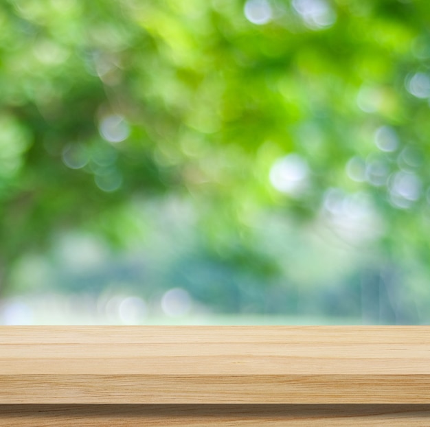 Table en bois pour l'affichage des produits alimentaires sur fond de jardin vert flou