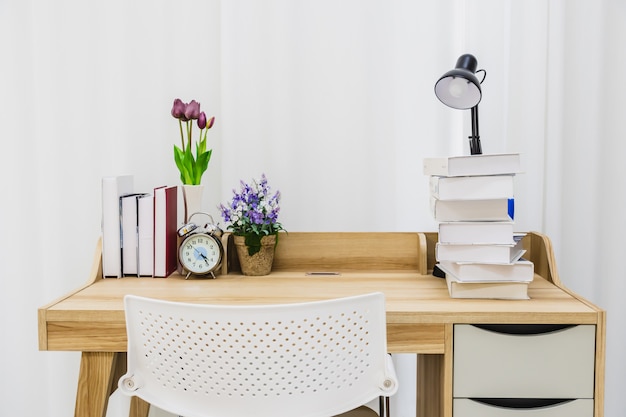 Une table en bois pour lire dans une salle blanche propre.