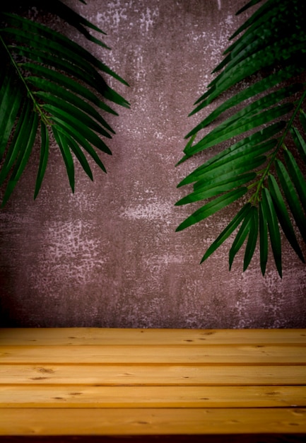 table en bois pour la présentation et la présentation du produit, des feuilles de palmier et un fond sombre et robuste
