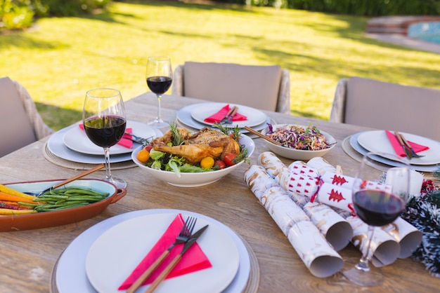 Une table en bois préparée pour un repas dans le jardin ensoleillé. Passer du temps ensemble dehors.