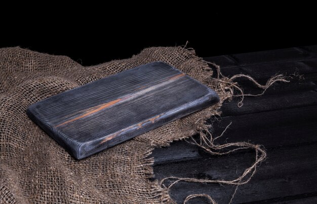 Table en bois sombre pour le produit, ancien intérieur en bois noir avec une vieille planche à découper