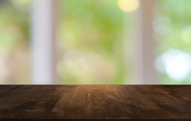 Une table en bois sombre vide devant l'arrière-plan abstrait bokeh flou du restaurant peut être utilisée pour l'affichage ou le montage de vos produits Maquette pour l'espace