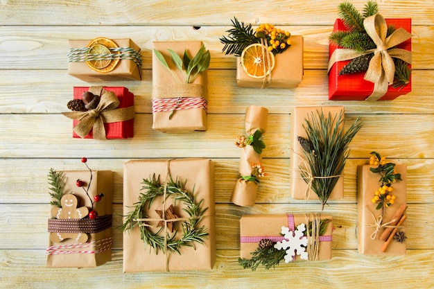 Sur une table en bois sont disposés des cadeaux de différentes formes et tailles Vue de dessus des cadeaux de Noël fabriqués à partir de matériaux sans déchets