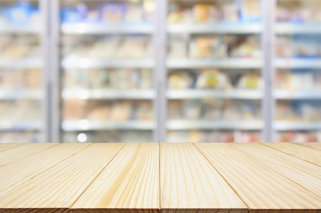 Table en bois avec supermarché réfrigérateurs commerciaux congélateur arrière-plan flou