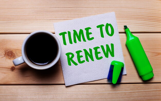 Sur Une Table En Bois, Une Tasse De Café, Un Marqueur Vert Et Une Serviette Avec Le Texte Time To Renew