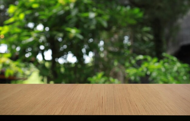 La table en bois vide devant l'arrière-plan flou abstrait du café peut être utilisée pour l'affichage ou le montage de vos produits Maquette pour l'affichage du produit