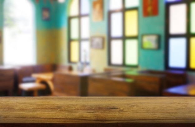 Photo table en bois vide devant le café abstrait flou intérieur de la maison de restaurant pour le produit de montage