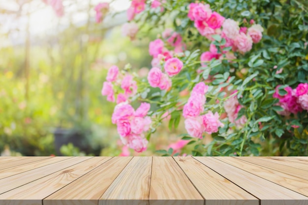 Photo table en bois vide avec fond de jardin de roses flou pour l'affichage des produits