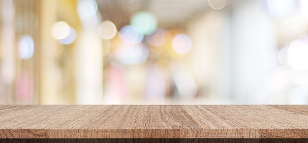 Table en bois vide sur fond de magasin de flou