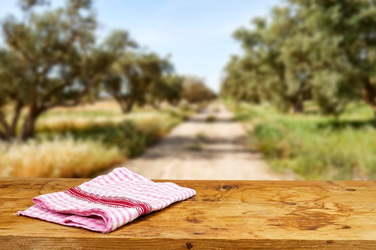 Photo table en bois vide avec nappe près du champ d'oliviers