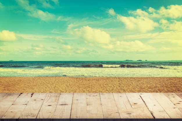 Photo table en bois vide pour l'affichage et le montage du produit sur la plage avec tonalité vintage.