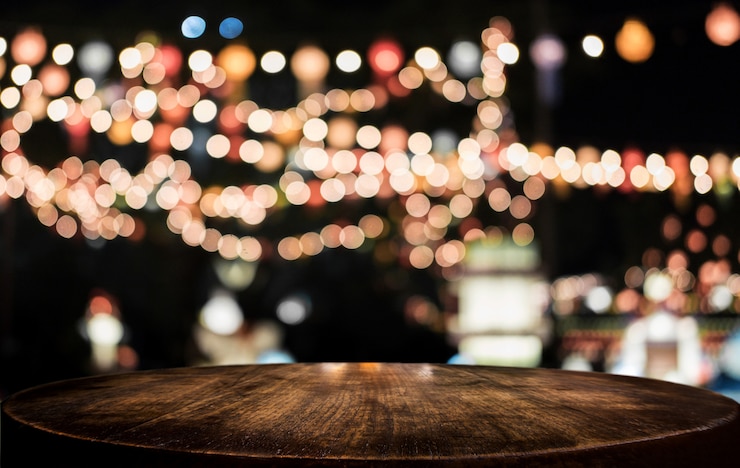 Photo table en bois vide sélectif en face de l&#39;abstrait abstrait floue lumière de fête avec des taches claires et bokeh